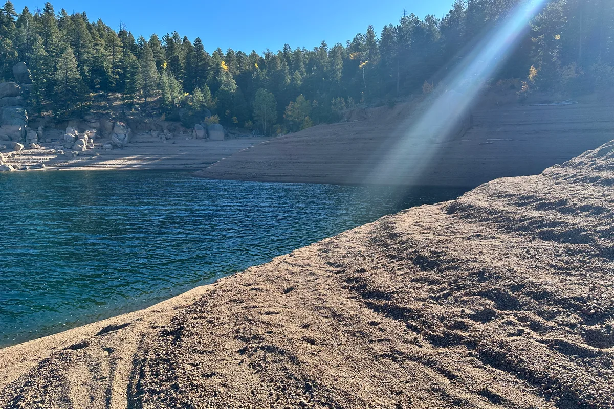 Sun rays on the beach at Rampart Reservoir in fall